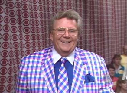 Rod is wearing a blue/purple/pink gingham jacket, matching necktie, dark-blue shirt with white collar & matching pocket square