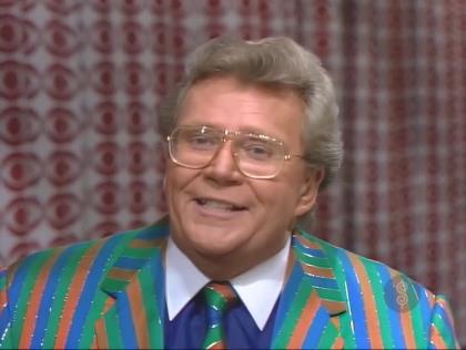 Rod is wearing a green/blue/orange-striped jacket with matching necktie & a dark-blue shirt with white collar