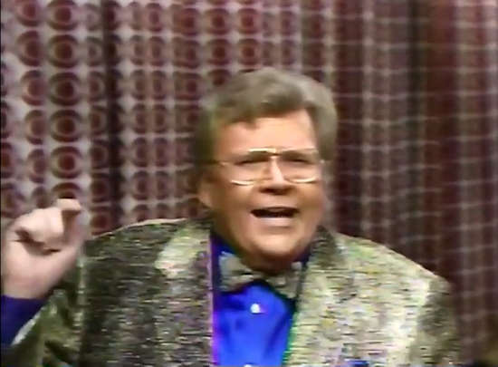 Rod is wearing a gold jacket, bow tie & blue silk shirt with matching pocket square