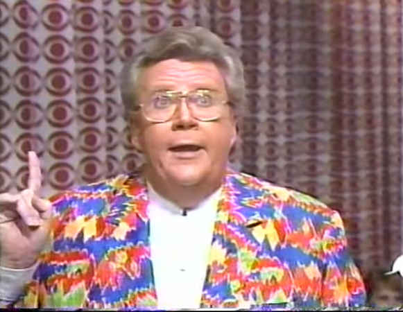 Rod is wearing a multi-colored Southwest-patterened jacket & white collarless shirt
