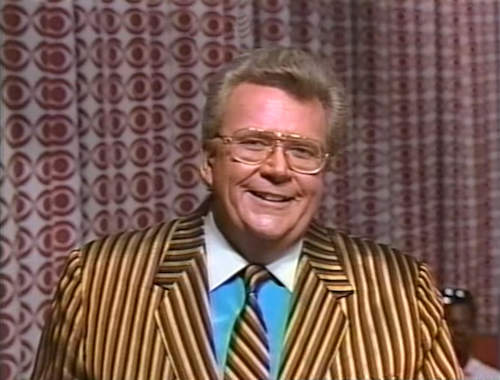 RRod is wearing a Gold/Brown/Black striped Jacket & Tie w/ Aqua shirt & white collar