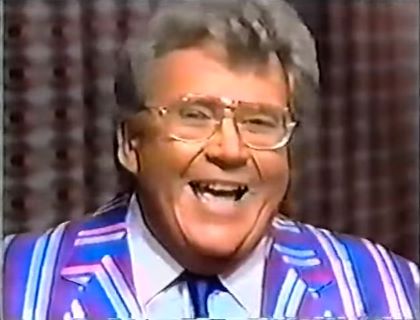 Rod is wearing a blue/purple/silver striped jacket, matching tie & white shirt