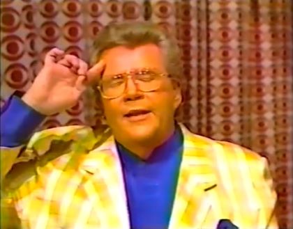 Rod is wearing a yellow gingham jacket & dark-blue collarless shirt w/matching pocket square