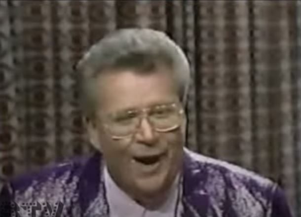 Rod is wearing a shiny purple jacket & white shirt