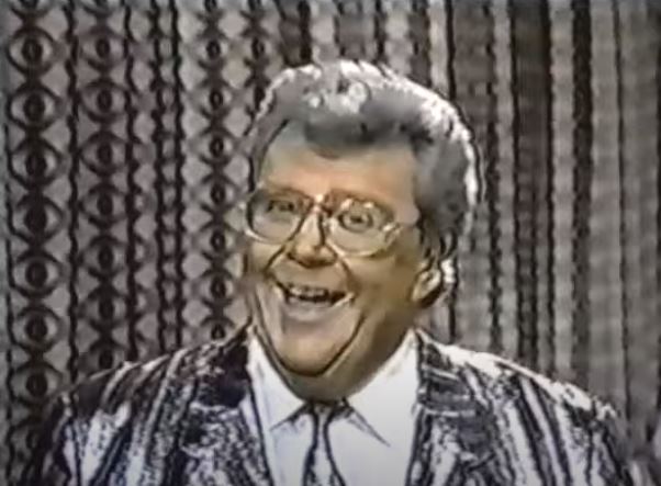 Rod is wearing a shiny silver & black-striped jacket, matching necktie & white shirt