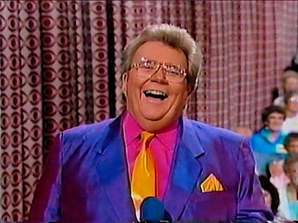 Rod is wearing a purple jacket, gold silk necktie with matching pocket square & fuchsia shirt