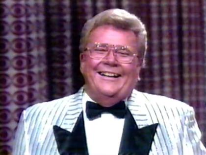 Rod is wearing a shiny white jacket with black pin-stripes & black lapels, a white shirt & black bowtie