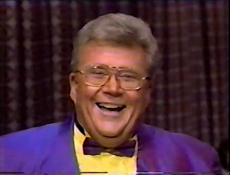 Rod is wearing a Purple Jacket with matching bow-tie & Yellow shirt