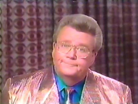 Rod is wearing a shiny-pink jacket, matching necktie and blue silk shirt