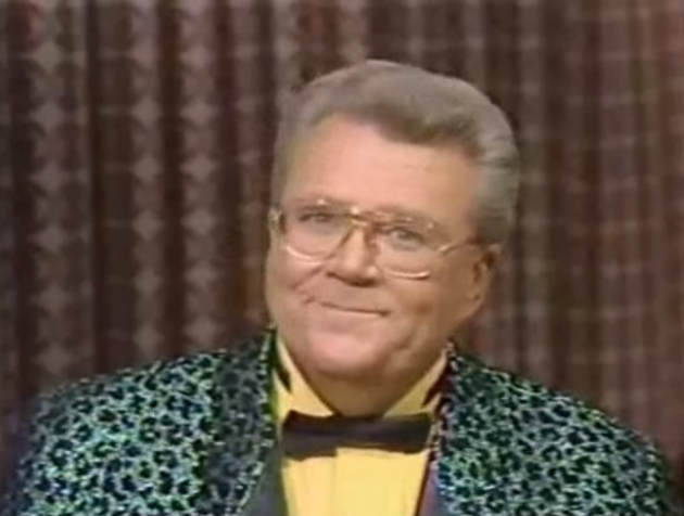 Rod is wearing a green leopard-print jacket with black lapels, black bow-tie & yellow shirt