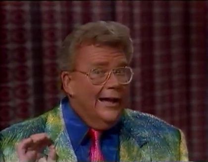 Rod is wearing a shiny dark-green/yellow jacket, shiny red necktie & dark-blue silk shirt