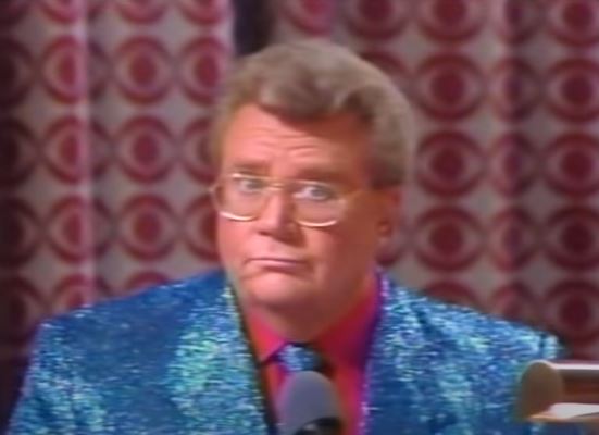 Rod is wearing a blue-sequined jacket & tie with a red shirt