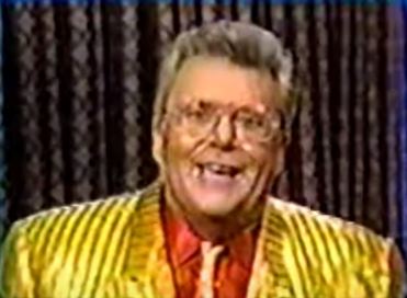 Rod is wearing a shiny yellow/yellow striped jacket, matching necktie & red silk shirt