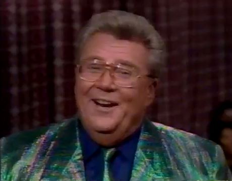 Rod is wearing an iridescent green jacket, matching necktie & blue shirt