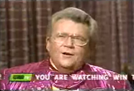 Rod is wearing a shiny pink/pink-striped jacket with matching ruffled bow-tie & yellow collarless silk shirt