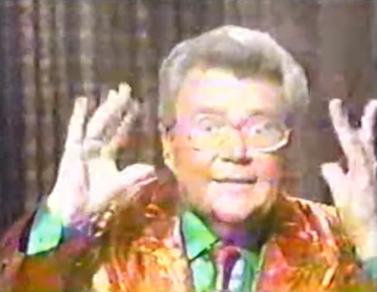 Rod is wearing a shiny red/red-striped jacket, matching tie & green silk shirt