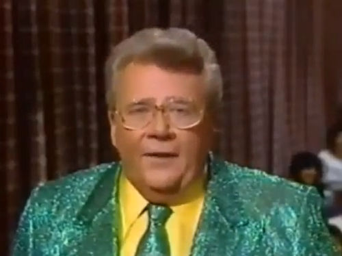 Rod is wearing a green sequined jacket, matching necktie & yellow shirt
