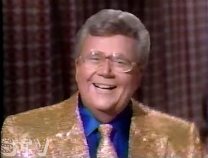 Rod is wearing a gold-sequined jacket, matching necktie & dark-blue silk shirt