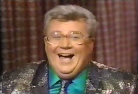 Rod is wearing a black sequined jacket, matching necktie & seafoam-green silk shirt