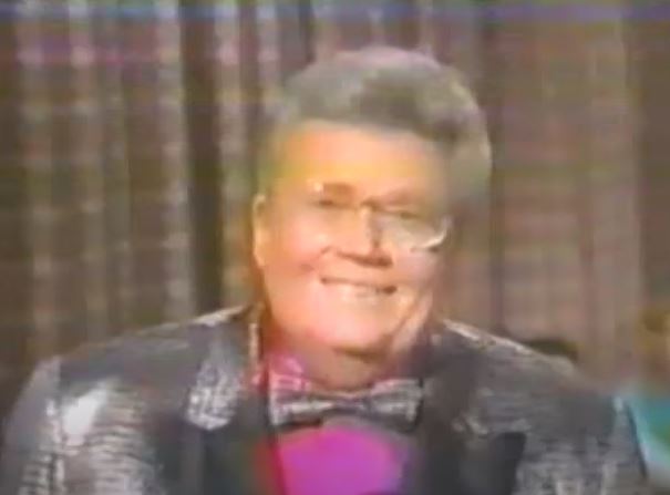 Rod is wearing a silver sequined jacket with black lapels, silver bow-tie & fuchsia shirt