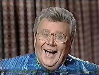 Rod is wearing a shiny blue/blue-striped jacket, matching ruffled bow-tie & white shirt