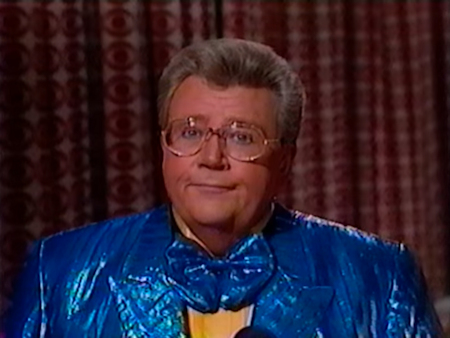 Rod is wearing a shiny blue/blue-striped jacket with matching bow tie & yellow shirt