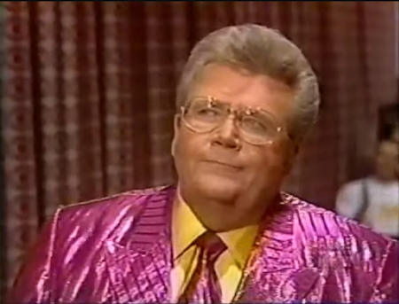 Rod is wearing a shiny pink/pink-striped jacket, matching neck-tie & yellow silk shirt