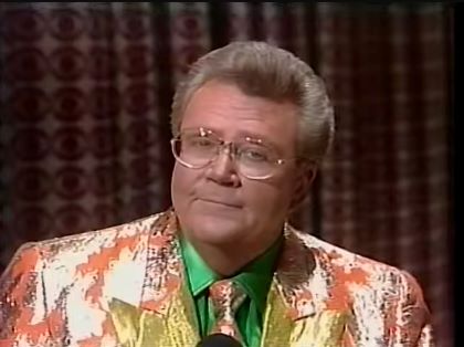 Rod is wearing a salmon jacket with gold streaks & gold lapels, matching necktie & a green silk shirt