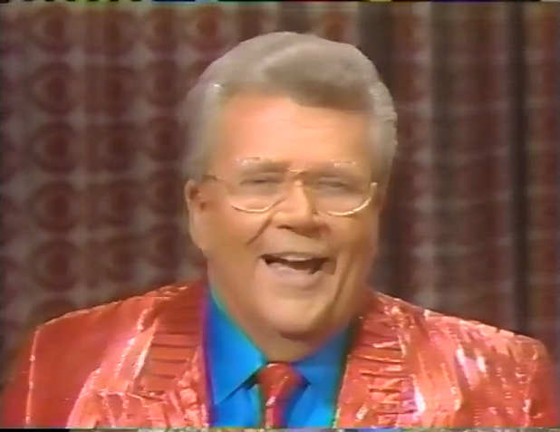 Rod is wearing a shiny red/red-striped jacket w/Matching Tie & Blue Shirt