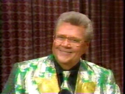 Rod is wearing a shiny green jacket with silver oak leaves and gold lapels, matching necktie & black silk shirt