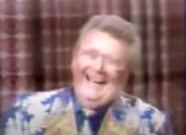 Rod is wearing a blue jacket with white 'clouds' & gold lapels, a matching tie & blue shirt