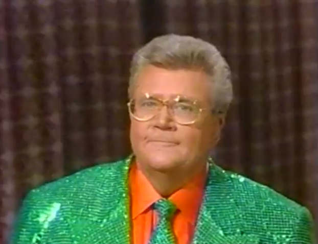 Rod is wearing a green sequined jacket, matching & orange shirt