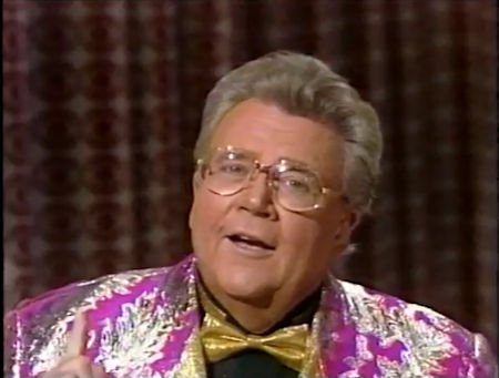 Rod is wearing a shiny fuchsia jacket with silver oak-leaves, a gold bow-tie & black shirt