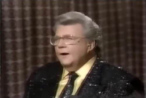 Rod is wearing a black sequined jacket, matching necktie & yellow silk shirt