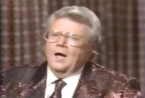 Rod is wearing a brown sequined jacket, matching necktie & white shirt