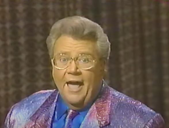 Rod is wearing a Pink/purple jacket & tie w/ blue shirt