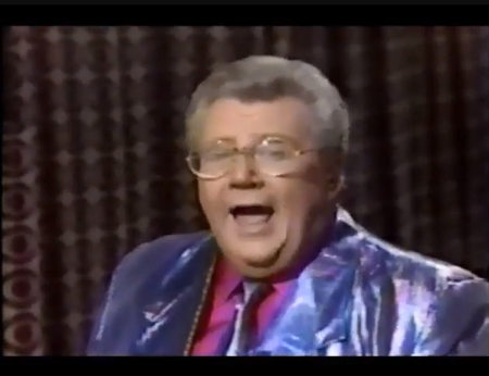 Rod is wearing a shiny blue-purple irridescent jacket with matching tie & fuchsia silk shirt