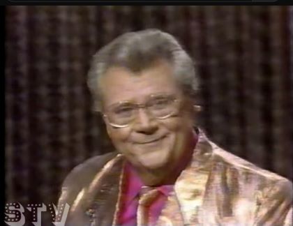 Rod is wearing a shiny-gold jacket, matching necktie & fuchsia shirt