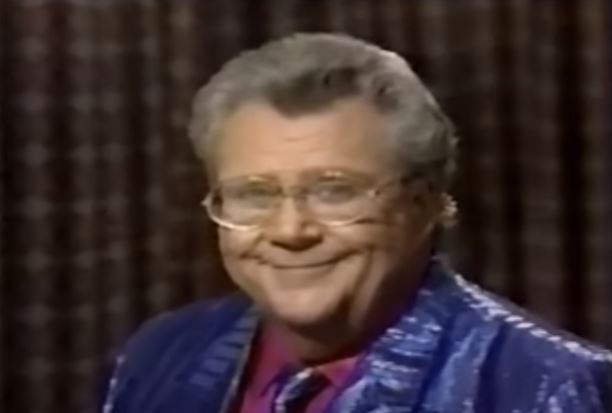 Rod is wearing a shimmery blue-striped jacket, matching tie & mauve shirt