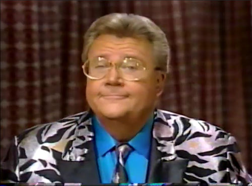 Rod is wearing a silver zebra-print jacket with black lapels, matching necktie & blue shirt