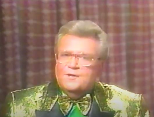 Rod is wearing a shiny gold jacket (with black lapels), matching bow tie & green shirt