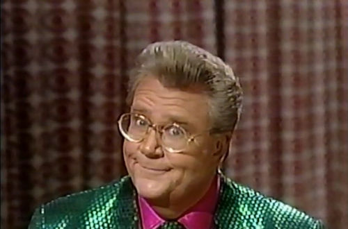 Rod is wearing as dark-green sequin jacket, matching tie & fuchsia shirt