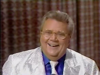 Rod is wearing a white-sequined jacket, matching necktie & dark-blue shirt