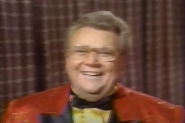 Rod is wearing a red sequined jacket with black lapels, black bow tie & yellow silk collarless shirt