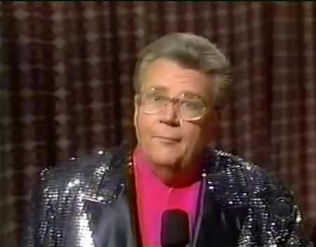 Rod is wearing a black sequined jacket with black lapels & fuchsia collarless silk shirt
