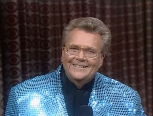 Rod is wearing a blue sequined jacket & navy-blue collarless silk shirt