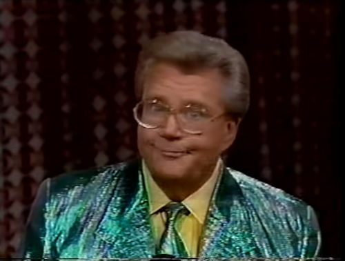 Rod is wearing an irredescent green jacket with matching necktie & yellow shirt