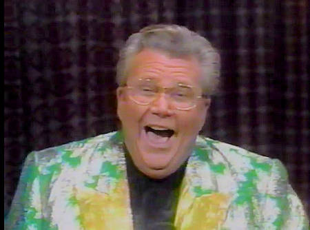 Rod is wearing a shiny green jacket with silver oak leaves and gold lapels and a black collarless silk shirt