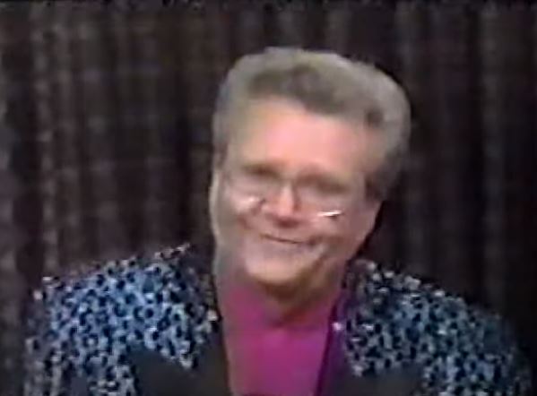 Rod is wearing a shiny blue leopard-print jacket & fuchsia silk collarless shirt