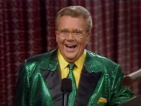 Rod is wearing a green-sequin jacket with black lapels and matching tie with a yellow shirt & pocket square